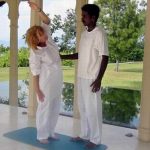 Frau dehnt sich im Ananda Spa Resort unter der Anleitung des Yogalehrers